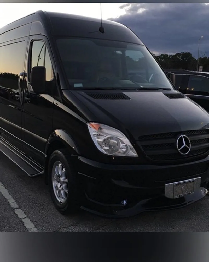 Prime Ride Shuttles black Sprinter van at dusk