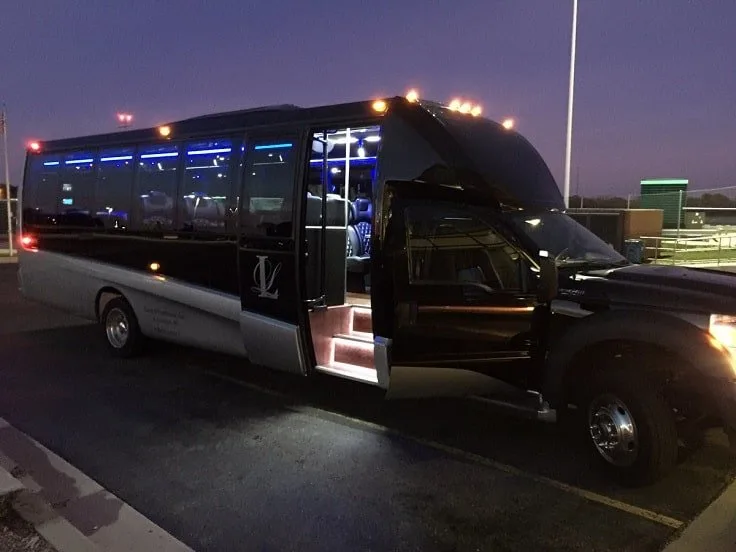 Black luxury party bus at dusk with its door open
